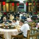 Group of Chinese people sitting and eating food in a Chinese Hotel.